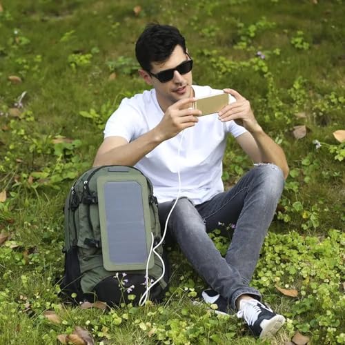 Homme chargeant son smartphone avec le panneau solaire du sac à dos en nature