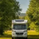 Camping-car blanc en plein soleil l été, illustrant le besoin de climatisation