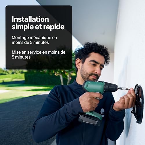 Homme installant la borne Wallbox au mur extérieur avec perceuse, montage rapide en moins de 5 minutes