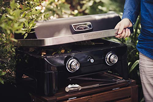 Utilisateur ouvrant le barbecue Campingaz Attitude 2100 LX sur terrasse extérieure avec ustensiles
