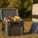 Glacière électrique à compression ouverte avec aliments frais, panneau solaire pliable et van aménagé au soleil — autonomie nomade