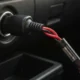 Fiche branchée dans une prise allume-cigare de tableau de bord, câble rouge et noir équipé d'un porte-fusible en ligne